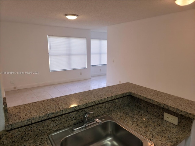 kitchen featuring light tile patterned floors, sink, and a textured ceiling