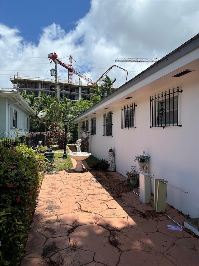 view of property exterior featuring a patio, fence, and stucco siding