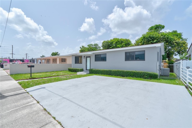 single story home with central AC unit and a front lawn