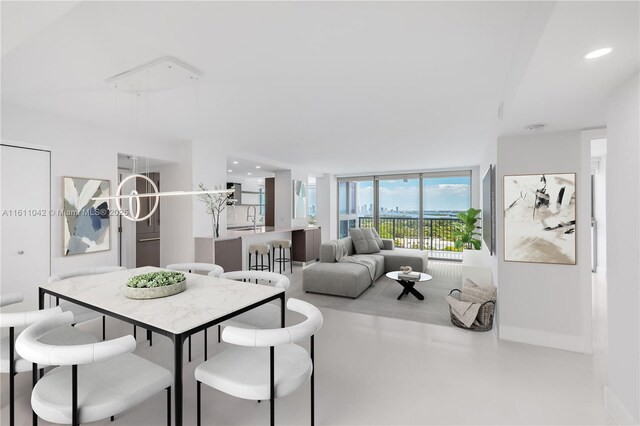 dining room featuring a wall of windows, sink, and concrete flooring