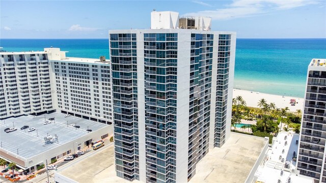 view of building exterior with a water view and a beach view