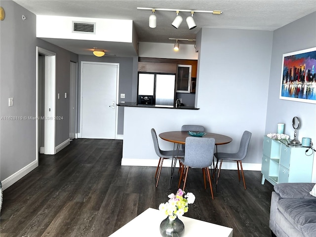 dining area with hardwood / wood-style floors and a textured ceiling