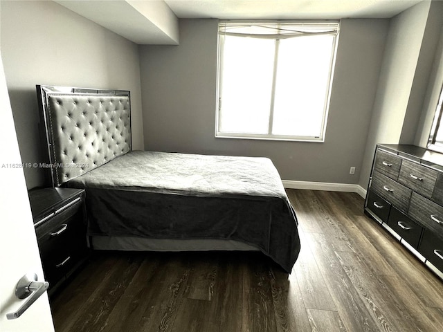 bedroom with dark hardwood / wood-style floors