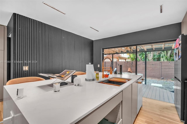 kitchen featuring plenty of natural light, light wood-type flooring, stainless steel refrigerator, and gray cabinets