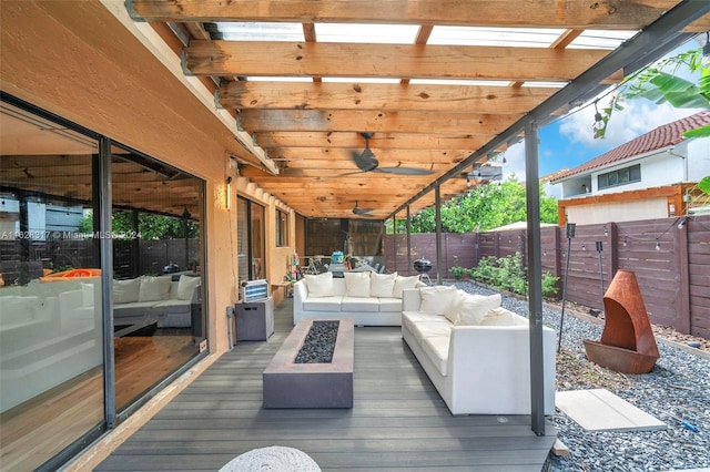 wooden deck featuring an outdoor living space with a fire pit and a fenced backyard