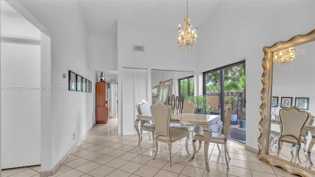 dining room with an inviting chandelier, light tile patterned floors, and high vaulted ceiling