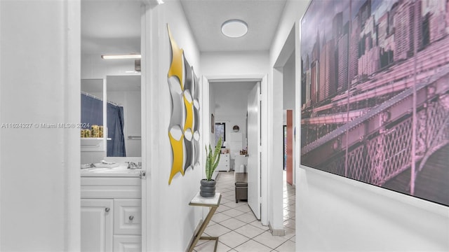 hallway featuring sink and light tile patterned floors