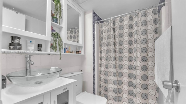 bathroom featuring vanity and tile walls