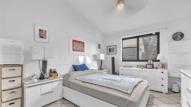 bedroom with light tile patterned floors and vaulted ceiling