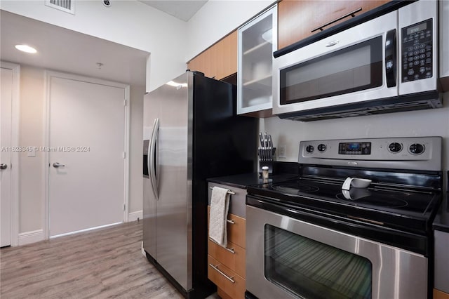 kitchen with light wood-type flooring and appliances with stainless steel finishes