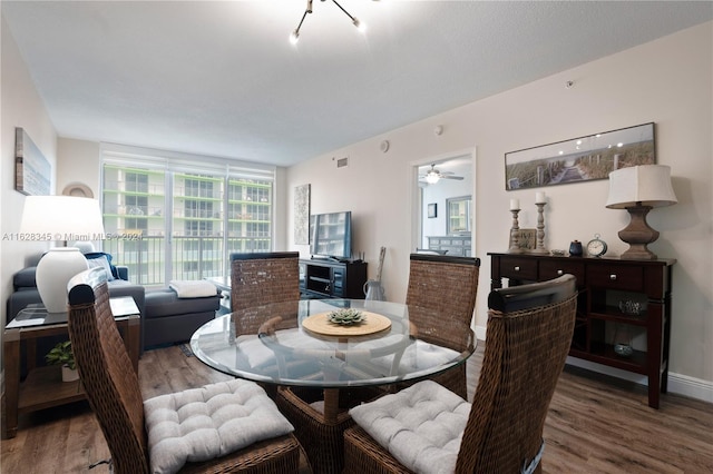 dining space with wood-type flooring and ceiling fan