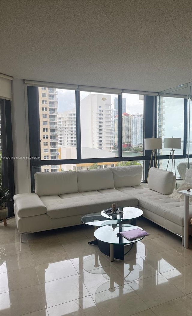 living room featuring a textured ceiling, a wealth of natural light, and a wall of windows