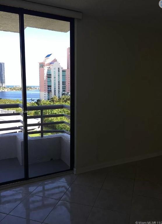 doorway with tile patterned floors, a healthy amount of sunlight, and a water view