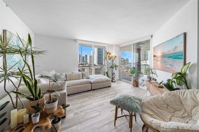 living room with expansive windows and light hardwood / wood-style flooring