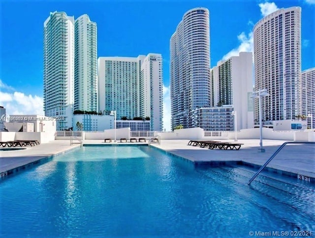 view of pool featuring a patio and a water view