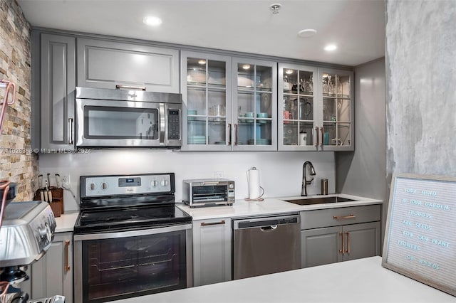 kitchen featuring gray cabinetry, sink, and stainless steel appliances