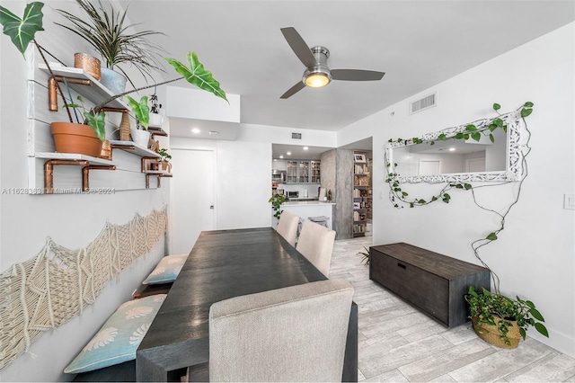 dining space with ceiling fan and light wood-type flooring