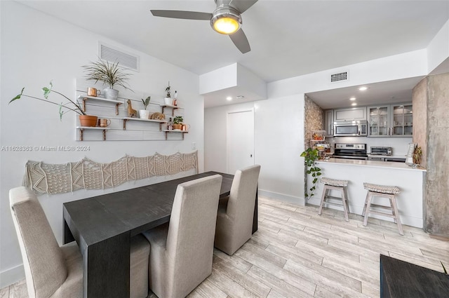 dining area with light hardwood / wood-style floors and ceiling fan