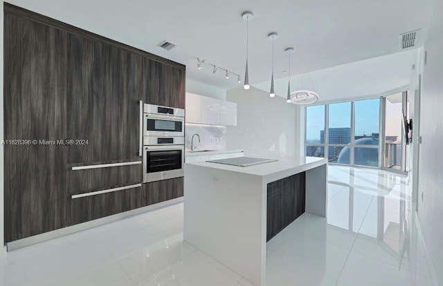 kitchen featuring a kitchen island, pendant lighting, white cabinets, decorative backsplash, and light tile patterned floors