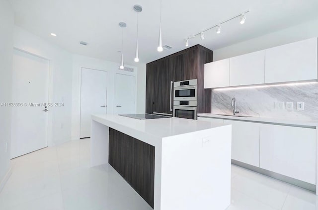 kitchen featuring sink, hanging light fixtures, dark brown cabinets, a center island, and white cabinets