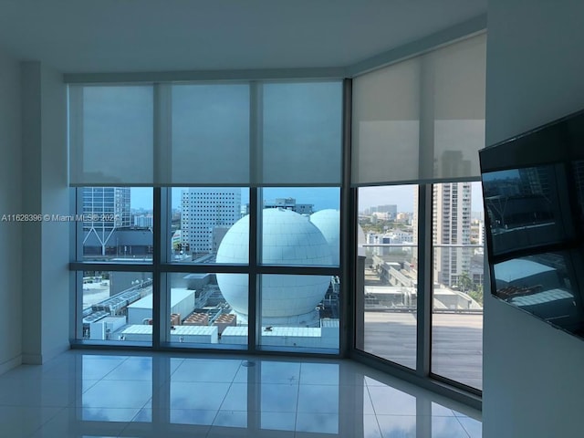 tiled spare room featuring expansive windows