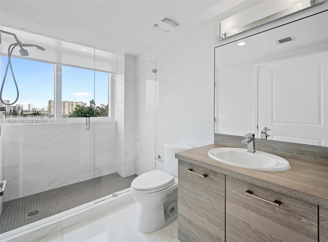 bathroom with a shower with shower door, vanity, toilet, and tile patterned floors