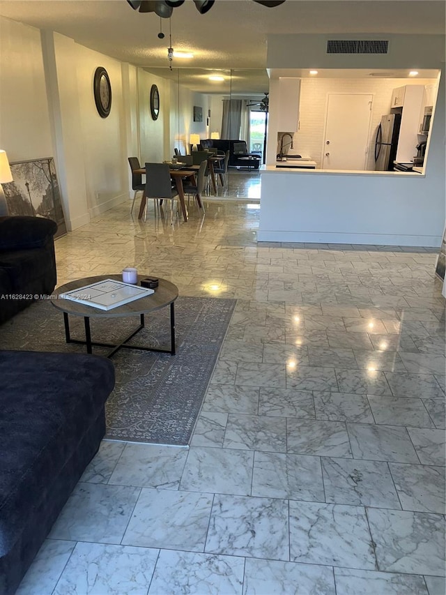 living room featuring sink, ceiling fan, and light tile patterned floors