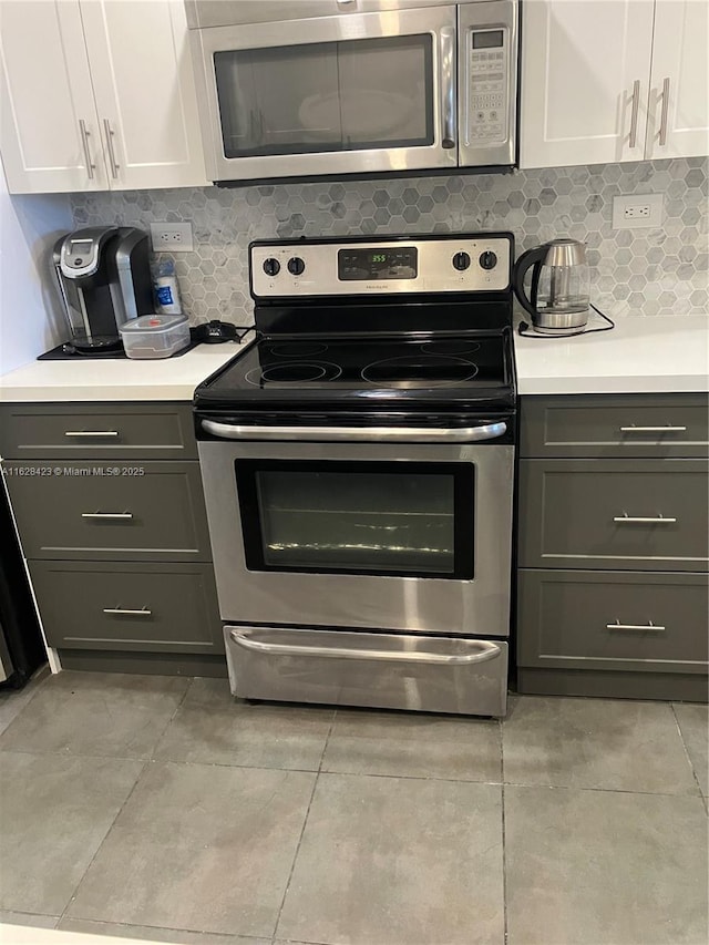 800 NE 195th St Unit 314, Miami, FL 33179 - kitchen featuring decorative backsplash, white cabinetry, appliances with stainless steel finishes, and light countertops