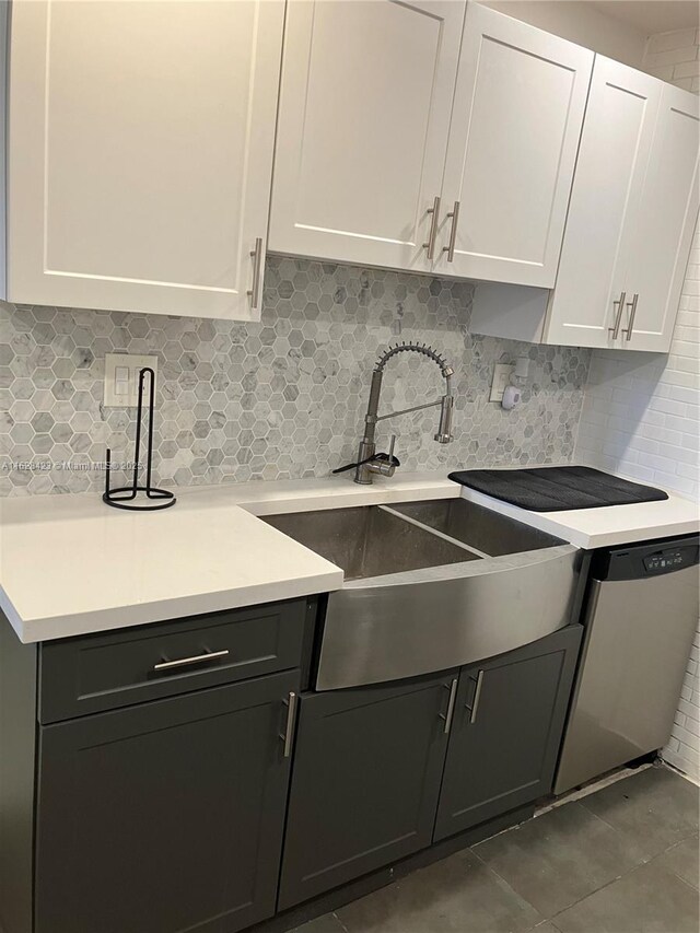 kitchen with tile patterned floors, white cabinetry, stainless steel dishwasher, and tasteful backsplash