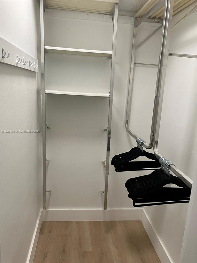 walk in closet with hardwood / wood-style floors