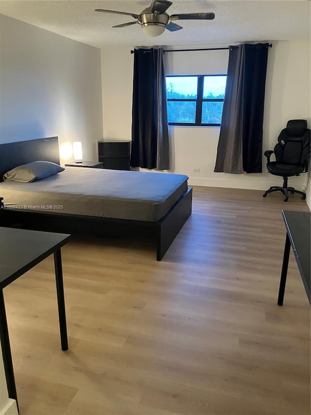 800 NE 195th St Unit 314, Miami, FL 33179 - bedroom with ceiling fan, wood finished floors, baseboards, and a textured ceiling