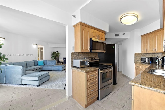 kitchen with sink, light tile patterned floors, tasteful backsplash, and stainless steel appliances