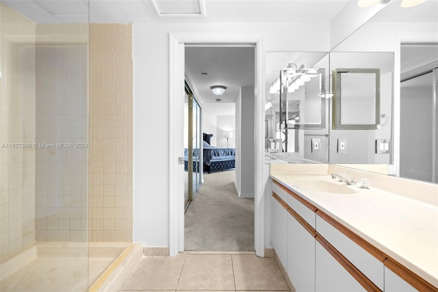 bathroom featuring vanity, a tile shower, and tile patterned floors