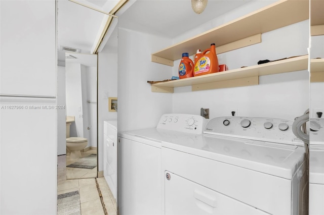 laundry area with light tile patterned floors and independent washer and dryer