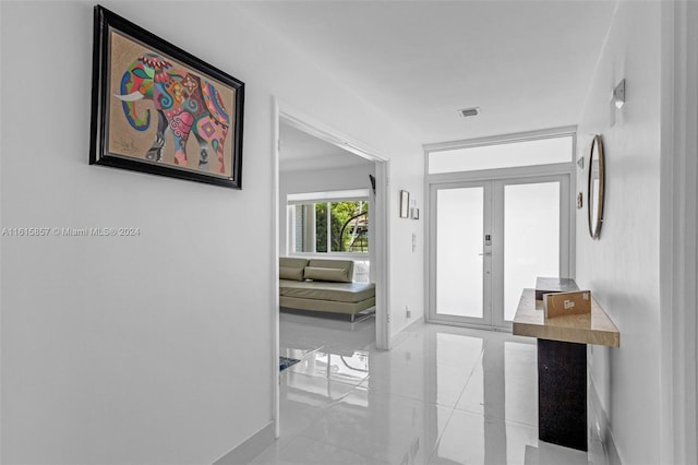 corridor featuring light tile patterned floors and french doors