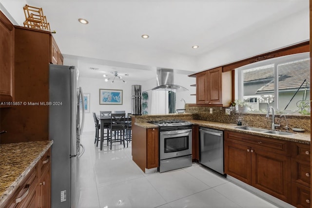 kitchen with appliances with stainless steel finishes, island range hood, light tile patterned floors, and stone countertops