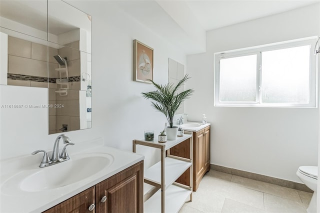 bathroom with tile patterned floors, vanity, a tile shower, and toilet