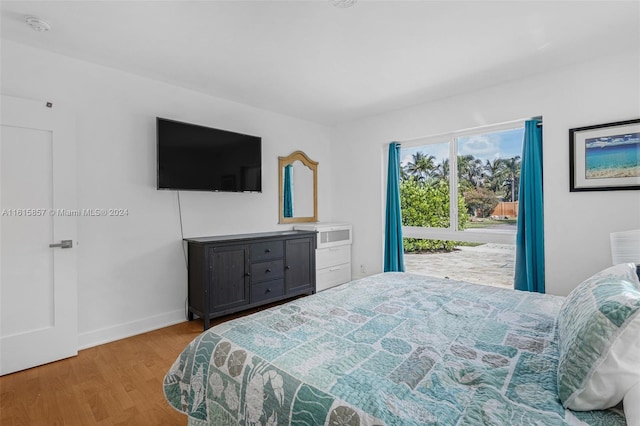 bedroom with multiple windows and hardwood / wood-style floors