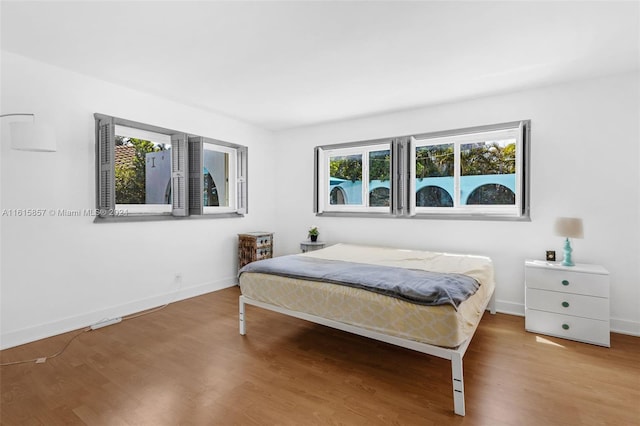 bedroom featuring hardwood / wood-style flooring and multiple windows