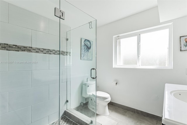 bathroom featuring vanity, toilet, tile patterned floors, and a shower with door