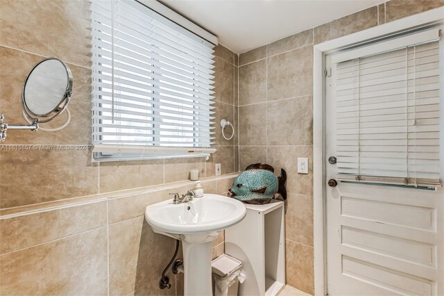 bathroom with sink and tile walls