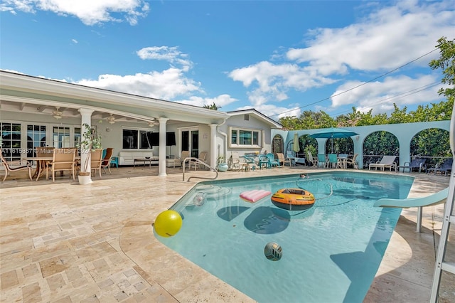 view of pool with a water slide, a patio, and ceiling fan