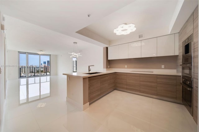 kitchen featuring kitchen peninsula, appliances with stainless steel finishes, white cabinets, hanging light fixtures, and light tile patterned floors