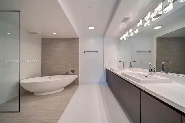 bathroom featuring double sink vanity, a tub to relax in, and tile patterned floors