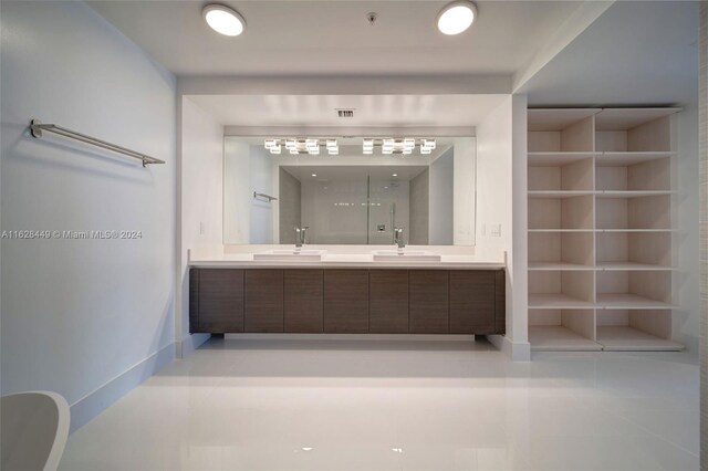 bathroom featuring double sink vanity, built in shelves, and tile patterned flooring