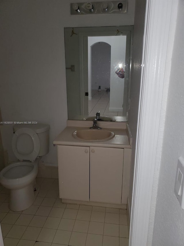 bathroom featuring tile patterned flooring, toilet, and vanity