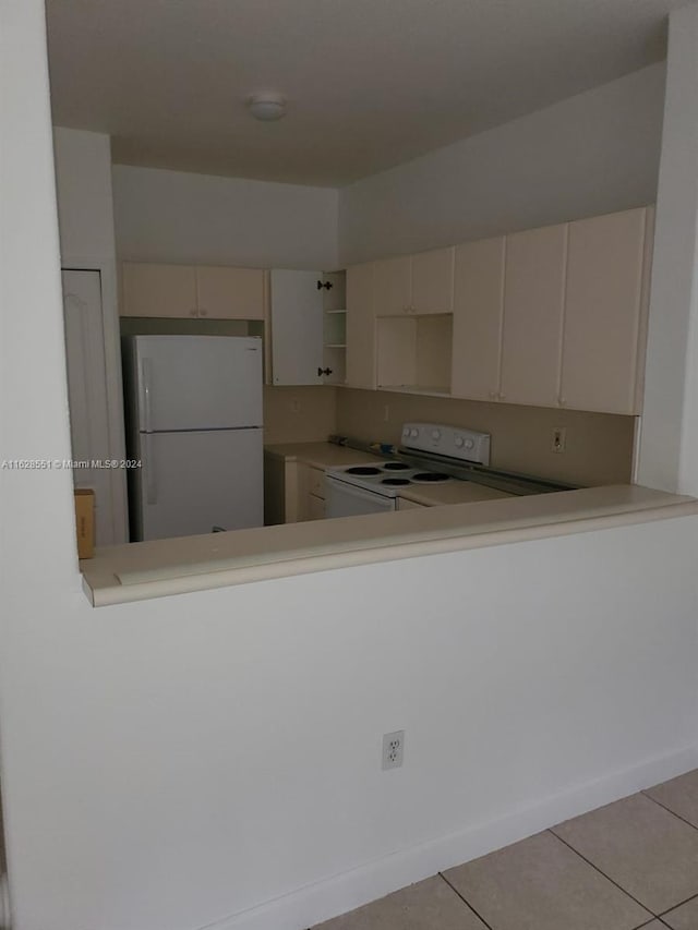 kitchen with light tile patterned flooring and white appliances