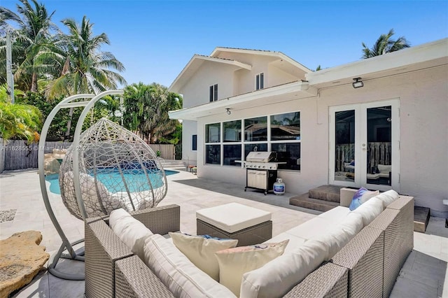 view of pool with pool water feature, a patio area, french doors, an outdoor living space, and grilling area