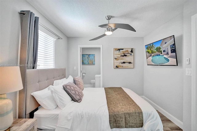 bedroom with ceiling fan, ensuite bathroom, hardwood / wood-style floors, and a textured ceiling