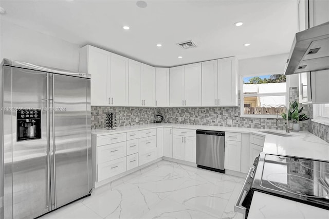 kitchen featuring sink, backsplash, white cabinets, and stainless steel appliances